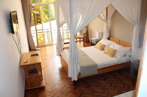 Riviera Garden في أنتاناناريفو: غرفة نوم بسرير مع ناموسية