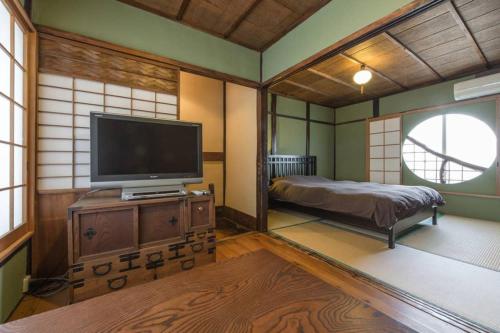 a large room with a tv and a bed in it at Sanjo Iho-an in Kyoto