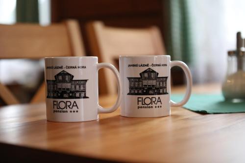 two coffee mugs sitting on top of a table at Penzion Flora in Janske Lazne