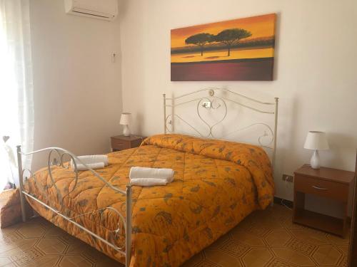 een slaapkamer met een bed met een geel dekbed bij B & B Patrizia in Isola Capo Rizzuto