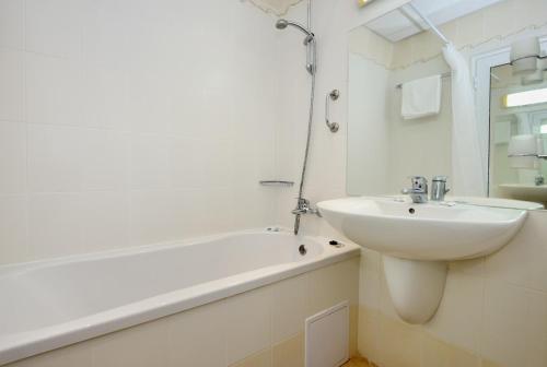 a white bathroom with a sink and a bath tub and a sink at Augusta SPA Hotel in Hisarya