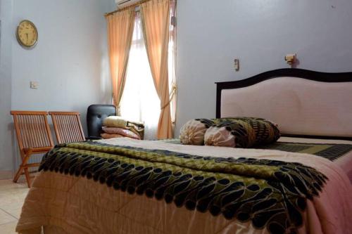 a bedroom with a large bed and a window at Samba Homestay in Kedaton
