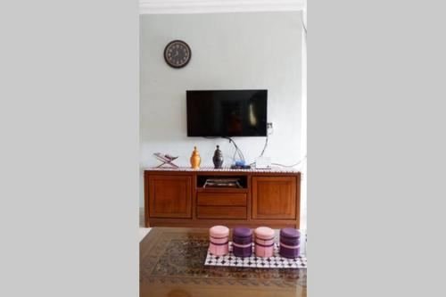 a living room with a tv and a cabinet at Samba Homestay in Kedaton