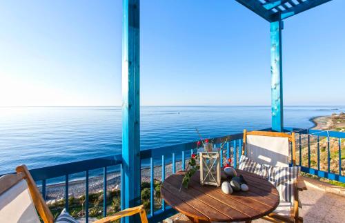 a table on a balcony with a view of the ocean at Mourayio Apartments in Pomos