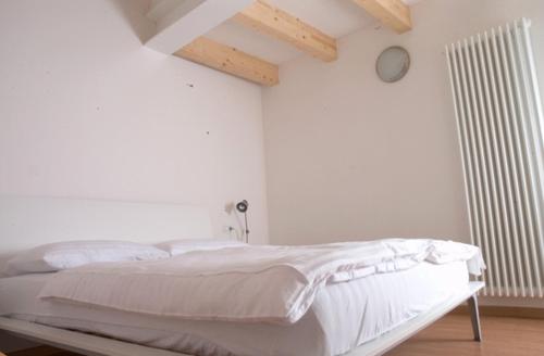 ein weißes Schlafzimmer mit einem Bett in einem Zimmer in der Unterkunft Windshouse in Nago-Torbole