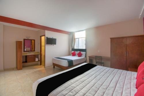 a hotel room with a bed and a television at Hotel San Pablo in Cholula