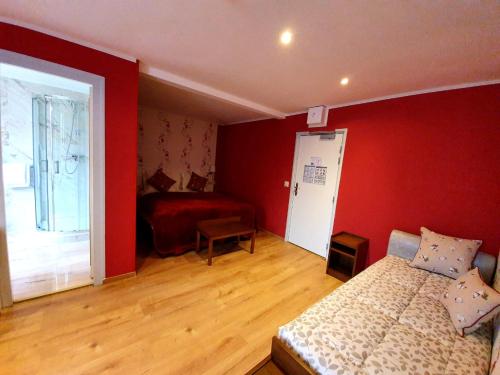 a bedroom with a bed and a red wall at Croix Blanche de Sologne in Chaumont-sur-Tharonne