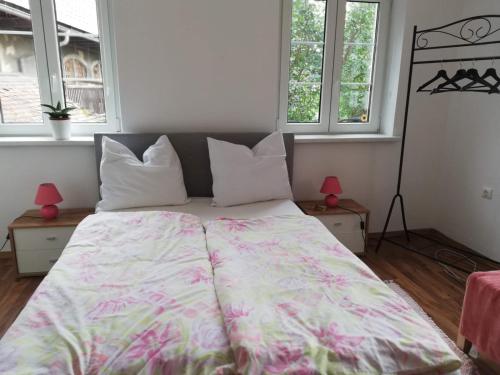 a large bed in a room with two windows at Land Wohnung in Gratkorn