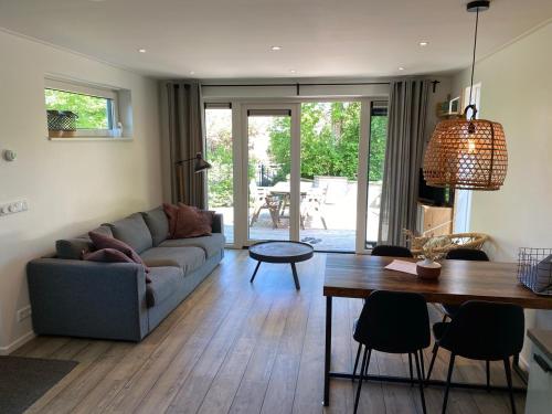 a living room with a couch and a table at Hello Zeeland - Vakantiehuis Duinenburg 22A in Domburg