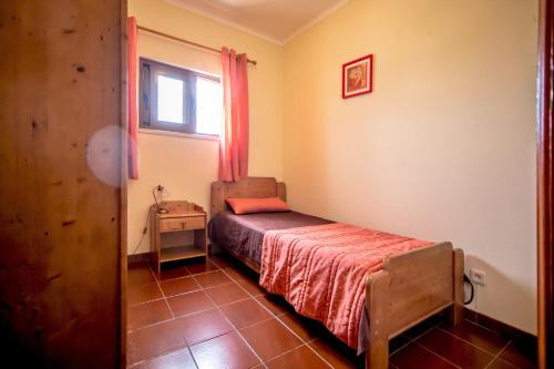 a small bedroom with a bed and a window at Atlantico Sul in Quarteira