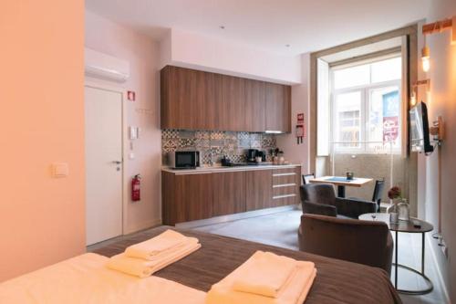 a small room with a bed and a kitchen at TMH Torrinha in Porto