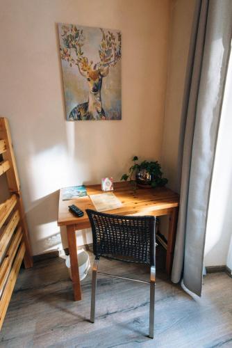 a wooden desk with a chair and a picture of a deer at Chalet de Lanza in Abriès
