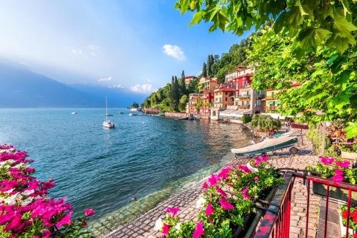 a view of a river with pink flowers and houses at Spa Tiny Love Apartment close to Milan-Como-Malpensa in Saronno