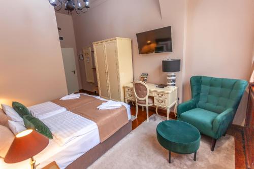 a bedroom with a bed and a chair and a desk at Belga Boutique Panzió in Debrecen
