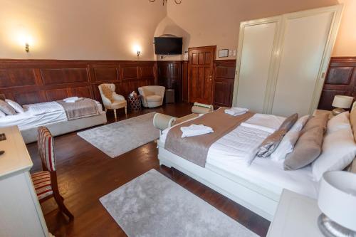 a hotel room with two beds and a television at Belga Boutique Panzió in Debrecen