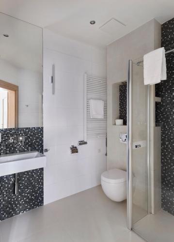 a white bathroom with a toilet and a sink at Columna Medica in Łask