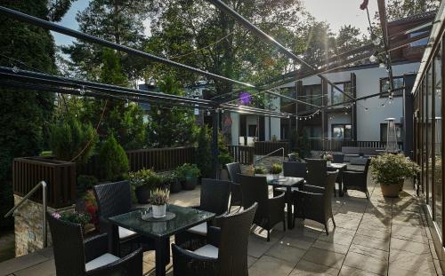 a patio with tables and chairs in a garden at Columna Medica in Łask