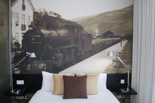 a bedroom with a mural of a train on the wall at LBV House Hotel in Pinhão