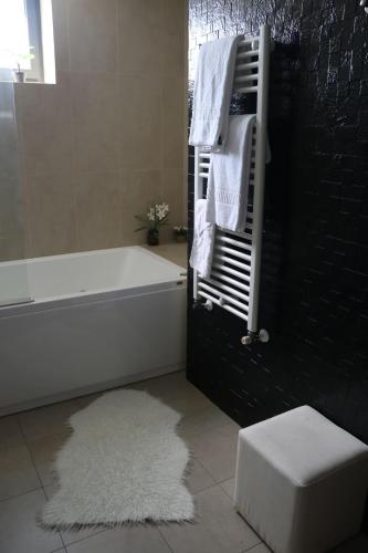 a bathroom with a bath tub and a white rug at LBV House Hotel in Pinhão
