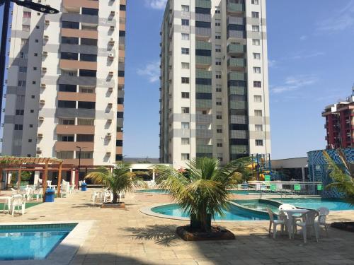 uma piscina com palmeiras e edifícios altos em Caldas Novas apto 5pessoas em Caldas Novas