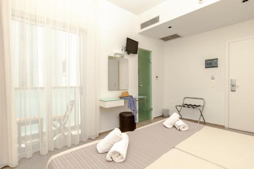 a bedroom with a bed and a desk and a window at Atlantis Boutique City Hotel in Rhodes Town