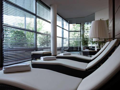 a room with four beds and a large window at Pullman Cologne in Cologne