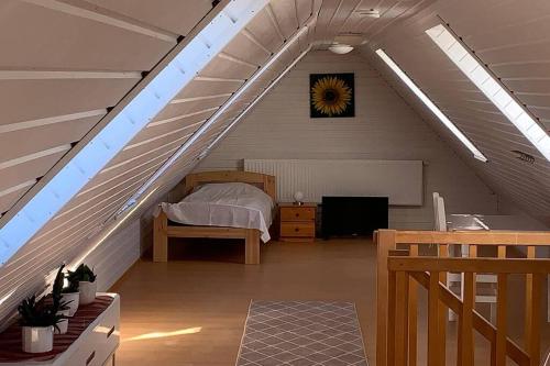 a attic room with a bed and a clock on the wall at Schöne gemütliche Ferienwohnung in Eggebek