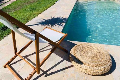 a straw hat and a chair next to a swimming pool at Casa Mira Tâmega in Marco de Canaveses