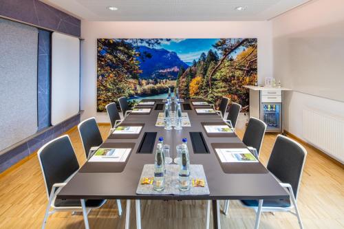 a long table in a room with a large wall mural at Hofgut Algertshausen in Eresing