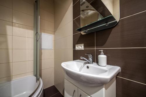 een badkamer met een wastafel, een toilet en een spiegel bij Apartment on Virmens`ka Street in Lviv