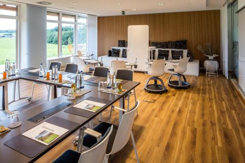 a conference room with tables and chairs and a kitchen at Hofgut Algertshausen in Eresing