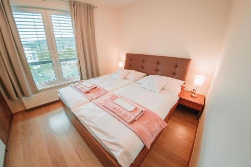 a large bed in a room with a large window at Aupark Apartment Peacock in Piešťany