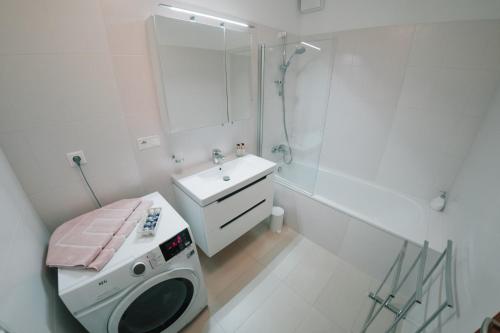 a bathroom with a washing machine and a sink at Aupark Apartment Peacock in Piešťany