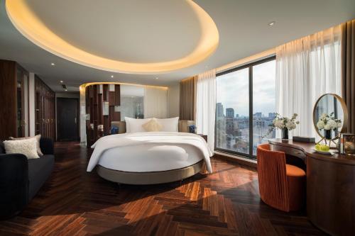 a bedroom with a large bed and a large window at Soleil Boutique Hotel Hanoi in Hanoi