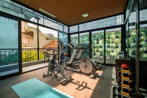 a gym with glass windows and a treadmill at Soleil Boutique Hotel Hanoi in Hanoi