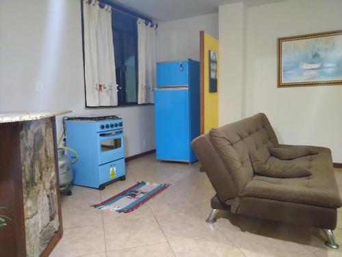 a living room with a couch and a blue refrigerator at Kitnet Aurora in Miguel Pereira