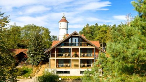 uma casa com um farol em cima dela em Róża Wiatrów em Węgorzewo