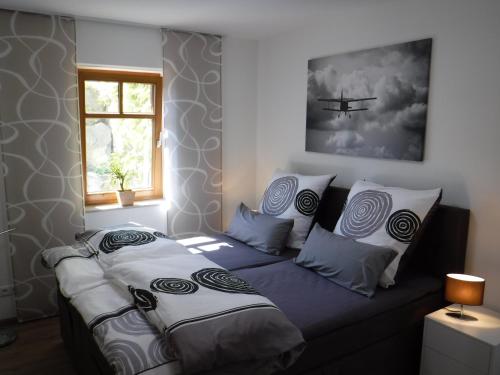 a bedroom with a bed with pillows and a plane at Ferienwohnung Mondfänger in Ehrenberg