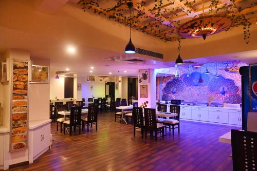 Un comedor con mesas y sillas y un bar. en Hotel Heritage Inn at Assi Ghat, en Varanasi