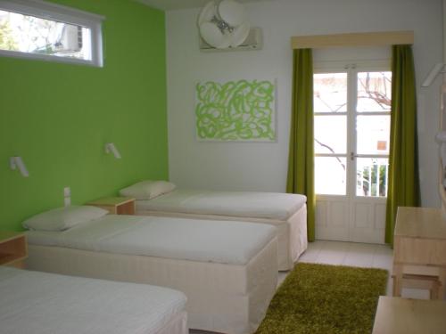 Zimmer mit 3 Betten und einem Fenster in der Unterkunft Manolis' House in Skiathos-Stadt