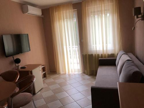 een woonkamer met een bank en een flatscreen-tv bij József Apartments House in Zalakaros