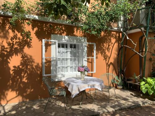 una mesa con un jarrón de flores junto a un edificio en Cozy Apartment in a Historic Villa, en Merano
