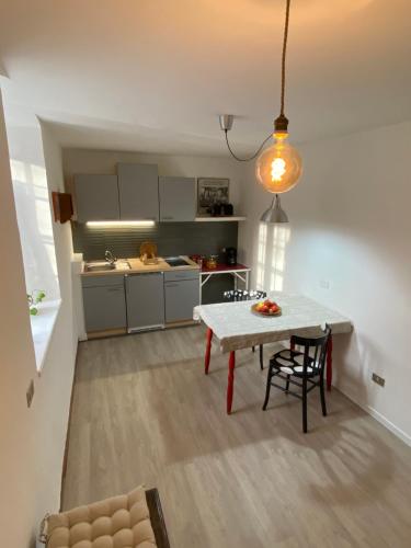 una pequeña cocina con mesa y comedor en Cozy Apartment in a Historic Villa en Merano