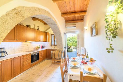 a kitchen with an archway and a table with food at Villa Philia Archontiko in Gavalochori
