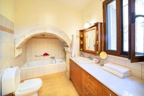 łazienka z wanną, toaletą i umywalką w obiekcie Villa Philia Archontiko w mieście Gavalochori
