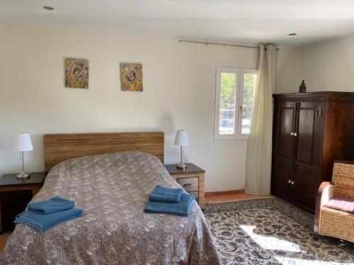 a bedroom with a bed with two blue towels on it at Finca las Estrellas in Relleu