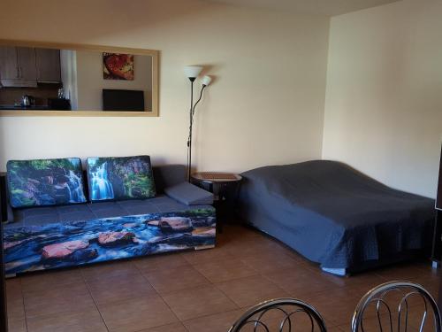 um quarto com uma cama, um sofá e uma mesa em Apartament Jacek em Kolobrzeg