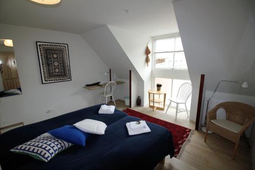 Un dormitorio con una cama azul con toallas. en Odense City B&B, en Odense