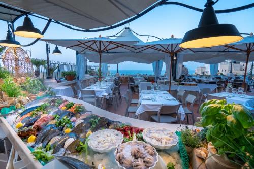 un buffet di cibo in un ristorante con vista sull'oceano sullo sfondo di Covo dei Saraceni a Polignano a Mare