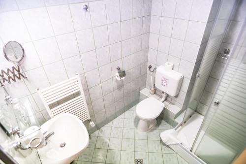 Baño blanco con aseo y lavamanos en 4 Évszak Hegyihotel, en Mátraháza